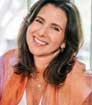 Head shot photo of author Marni Battista smiling and wearing orange blazer